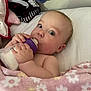 baby, bottle, milk, blanket, pink, floral, curious, face, hand, bed, pillow, soft, infant, child, indoors, cute, feeding, sleeping_area, resting, person