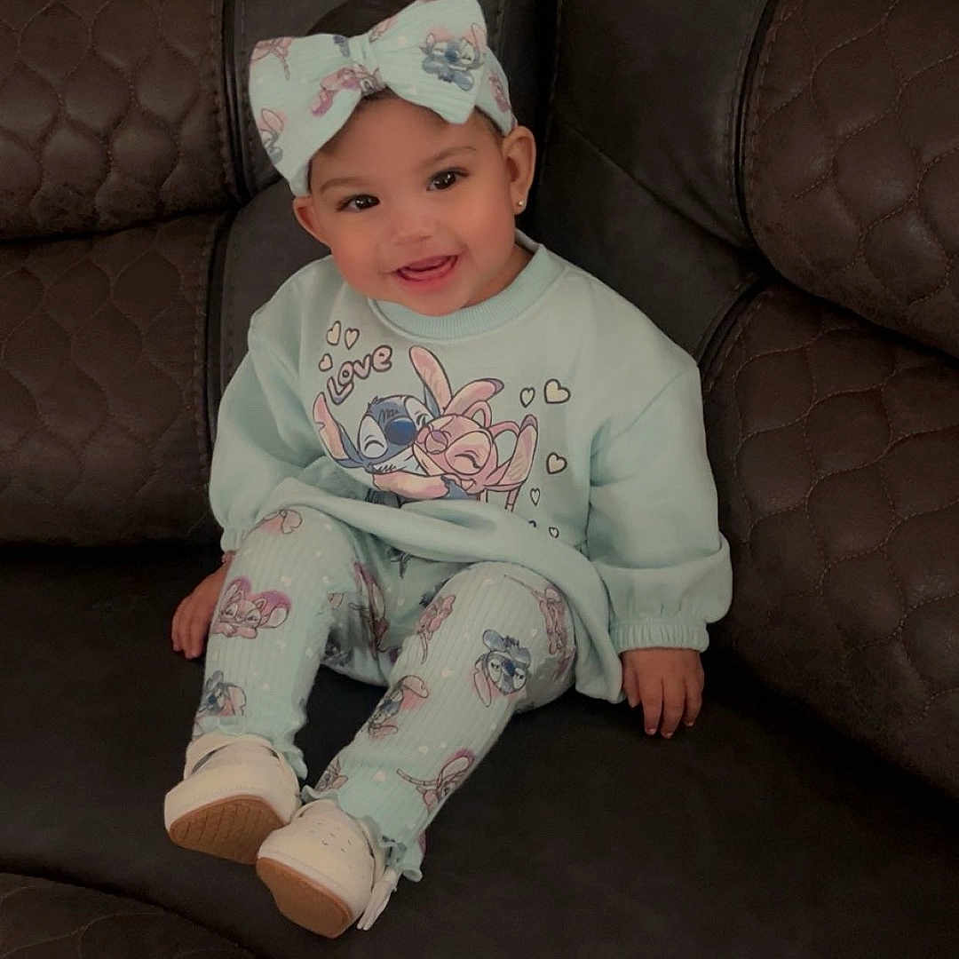 Azaleah is registered to the contest to win money with this photo: baby, bow, cartoon_print, child, cozy, cute, fashion, happy, headband, indoor, infant, leather, leggings, person, portrait, seated, shoes, smile, sofa, sweatshirt