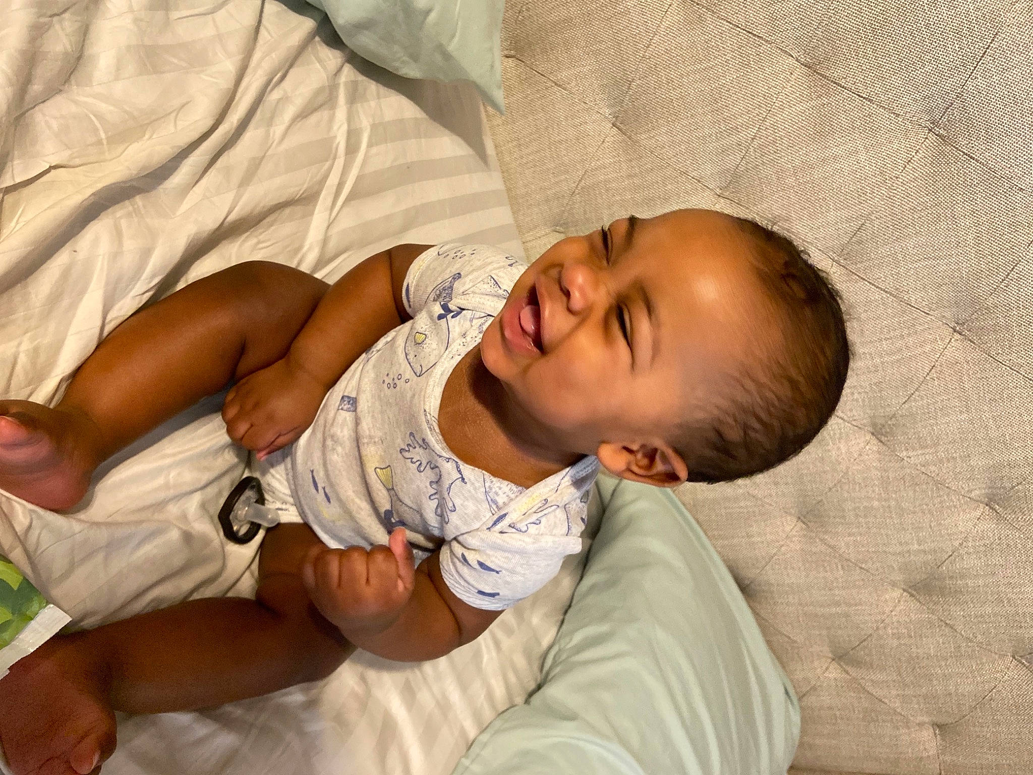 Josiah is registered to the contest to win money with this photo: abdomen, baby, baby_toddler_clothing, bedtime, child, comfort, elbow, event, foot, gesture, happy, linens, mouth, nap, pattern, person, skin, sleep, sleeve, smile