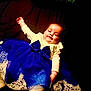 baby, child, dress, blue_dress, bow, lace, smile, face, infant, cute, sitting, clothing, portrait, indoors, person, young_child, happy, fashion, toddler, celebration