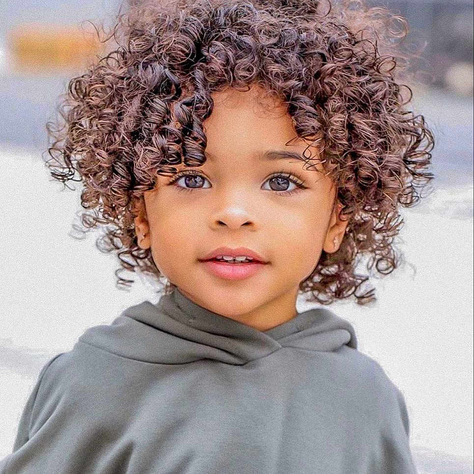 Nélyo participe au concours pour gagner de l'argent avec cette photo : casual_clothing, child, childhood, closeup, curly_hair, cute, expression, eyes, face, fashion, hair, happy, hoodie, innocence, outdoor, person, portrait, skin, smile, young