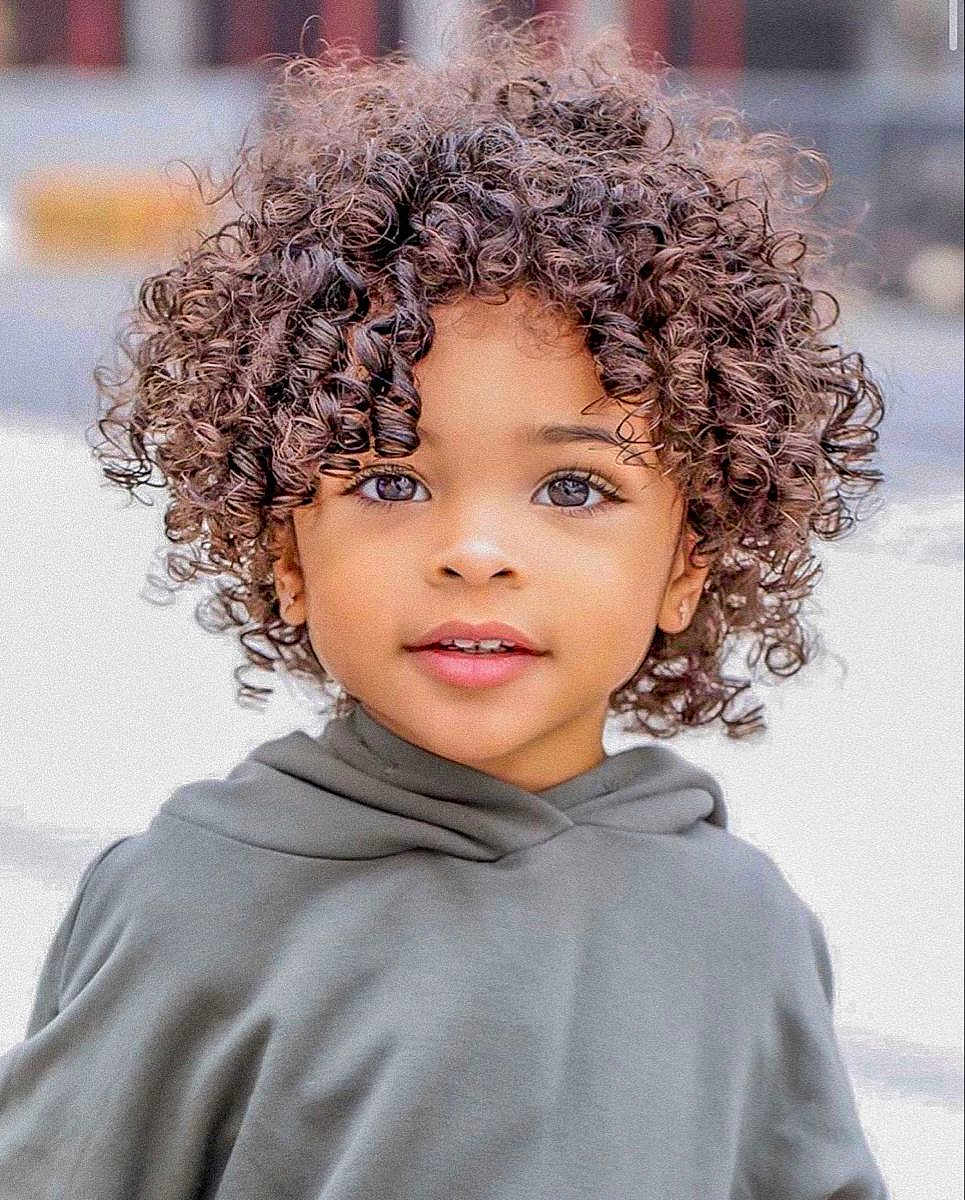 Nélyo participe au concours pour gagner de l'argent avec cette photo : child, curly_hair, face, eyes, hoodie, smile, portrait, young, cute, outdoor, person, fashion, expression, skin, childhood, casual_clothing, hair, closeup, innocence, happy