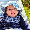 baby, child, smiling, hat, blue_hat, outdoor, stroller, clothing, infant, sun_hat, portrait, happy, cute, face, young_child, nature, daylight, seatbelt, patterned_clothing, closeup