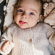 Liam a rejoint le concours — aidez-le/la à gagner de superbes lots ! baby, blue_eyes, tongue_out, knitted_sweater, blanket, pacifier, plush_toy, infant, cute, cozy, lying_down, soft_texture, close_up, child, face, expression, indoors, warm, comfortable, portrait