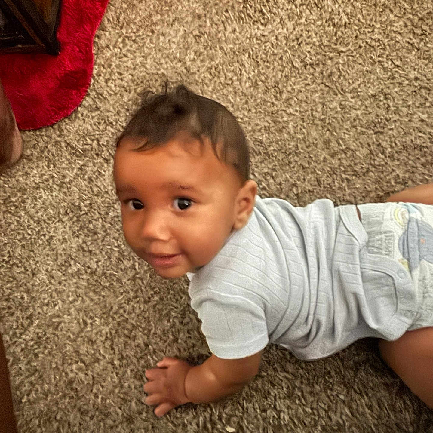 Jessie joined the competition — help win amazing prizes! baby, infant, crawling, carpet, floor, blue_onesie, child, cute, indoor, person, smile, skin, hair, red_fabric, texture, homedecor, baby_clothing, young_child, play, looking