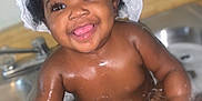Lyric is registered to the contest to win money with this photo: baby, bath, water, sink, smile, happy, child, curly_hair, towel, wet_skin, splashing, cute, indoors, playful, face, joyful, skin, person, closeup, toddler
