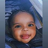 Myla is registered to the contest to win money with this photo: baby, child, smiling, car_seat, blanket, face, happy, infant, seatbelt, cozy, portrait, closeup, cute, young_child, indoors, warm, clothing, head, person, baby_face