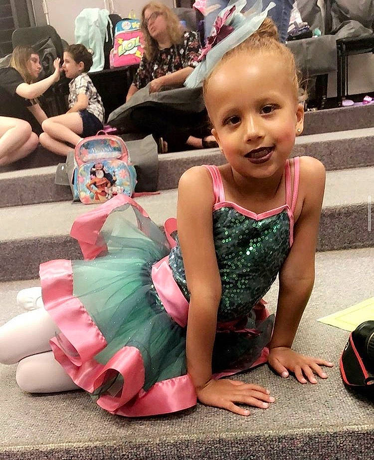 Keonna is registered to the contest to win money with this photo: child, dance, dress, event, footwear, head, people, performance, person, pink, shoe, sitting, smile, summer, toddler, vacation