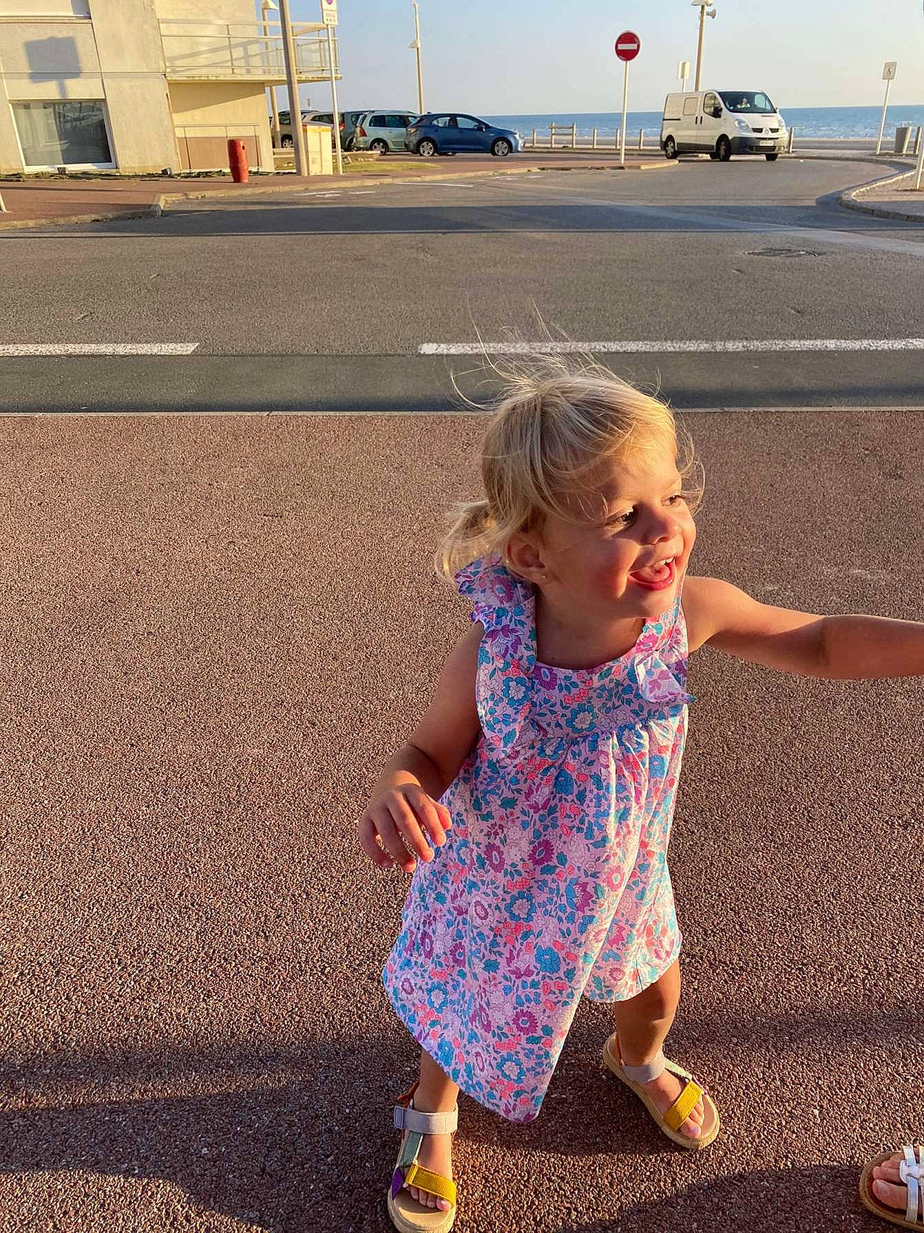 Kaina participe au concours pour gagner de l'argent avec cette photo : asphalt, baby_toddler_clothing, dress, fun, grass, hair, happy, infrastructure, leg, leisure, light, line, morning, people_in_nature, person, photograph, road_surface, sky, summer, toddler