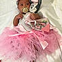 baby, infant, tutu, pink, headband, flower, pacifier, plush_toy, minnie_mouse, blanket, soft, cute, foot, hand, person, lying_down, clothing, child, indoor, portrait