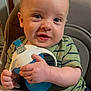 baby, child, high_chair, sippy_cup, green_shirt, striped_clothing, happy, smiling, indoor, curly_hair, face, hands, cute, infant, person, portrait, young_child, feeding, seat, expression