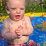 baby, bare_chest, child, clothing, daytime, fence, fun, grass, happy, outdoor, play, pool, shorts, sitting, splash, summer, sunlight, toddler, water, water_droplets