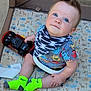 baby, bandana, blue_eyes, bright_colors, child, colorful_toys, curious_expression, cute, floor_mat, indoor, infant, neon, patterned_clothing, plastic_toys, playpen, playtime, seated, shirt, socks, toy_car