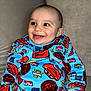 Fayver a rejoint le concours — aidez-le/la à gagner de superbes lots ! baby, smiling, child, blue_clothing, cartoon_print, couch, happy, indoors, portrait, cute, young_child, face, sitting, long_sleeves, colorful, cozy, person, infant, bright, clothing