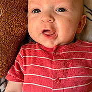 Jaxson joined the competition — help win amazing prizes! baby, child, closeup, cute, expression, face, head, indoors, infant, lying_down, newborn, onesie, person, pillow, portrait, red_clothing, skin, soft_texture, striped_clothing, young_child