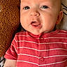 baby, child, closeup, cute, expression, face, head, indoors, infant, lying_down, newborn, onesie, person, pillow, portrait, red_clothing, skin, soft_texture, striped_clothing, young_child