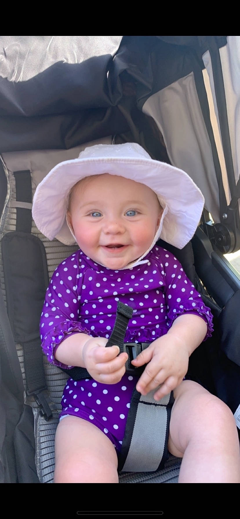 Lainey is registered to the contest to win money with this photo: arm, baby_carriage, baby_toddler_clothing, clothing, facial_expression, finger, gesture, hairstyle, hand, happy, headwear, iris, leg, lip, person, pink, product, purple, skin, sleeve