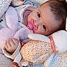 Ava participe au concours pour gagner de l'argent avec cette photo : baby, pacifier, blanket, stuffed_toy, plush, infant, soft_toy, clothing, hand, face, cute, child, portrait, indoor, cozy, sleepwear, pink, white, resting, cuddling