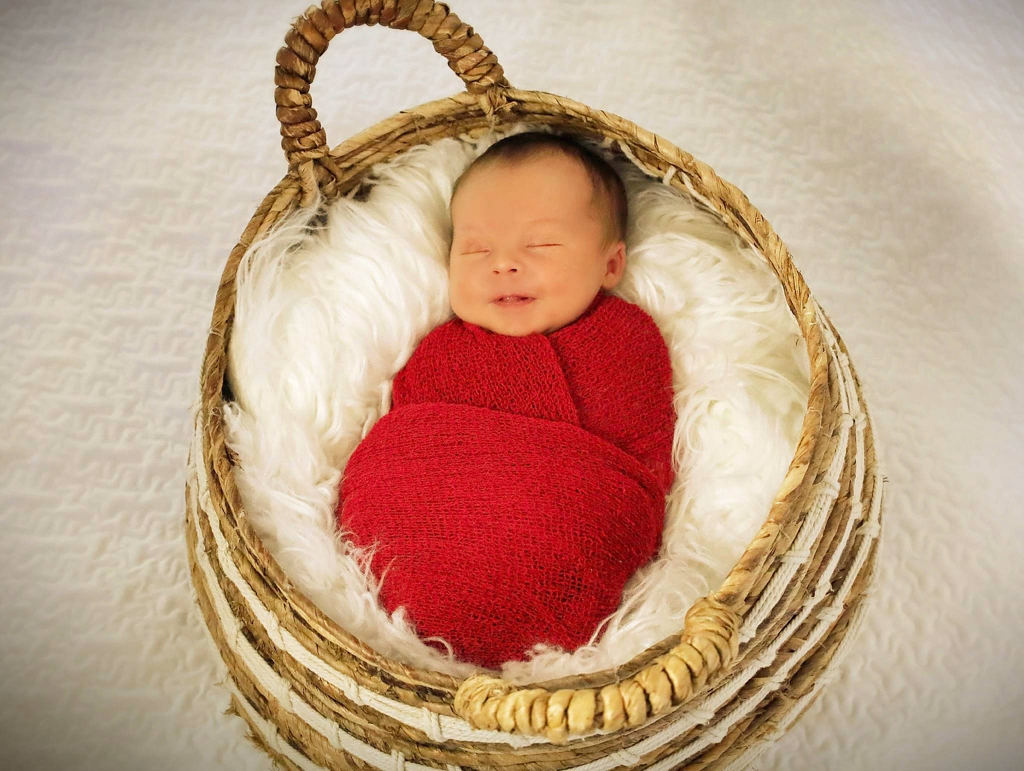 Abel is registered to the contest to win money with this photo: baby, baby_products, baby_sleeping, baby_toddler_clothing, basket, child, circle, comfort, eye, face, fashion_accessory, happy, head, infant_bed, linens, person, textile, toddler, wicker, wood