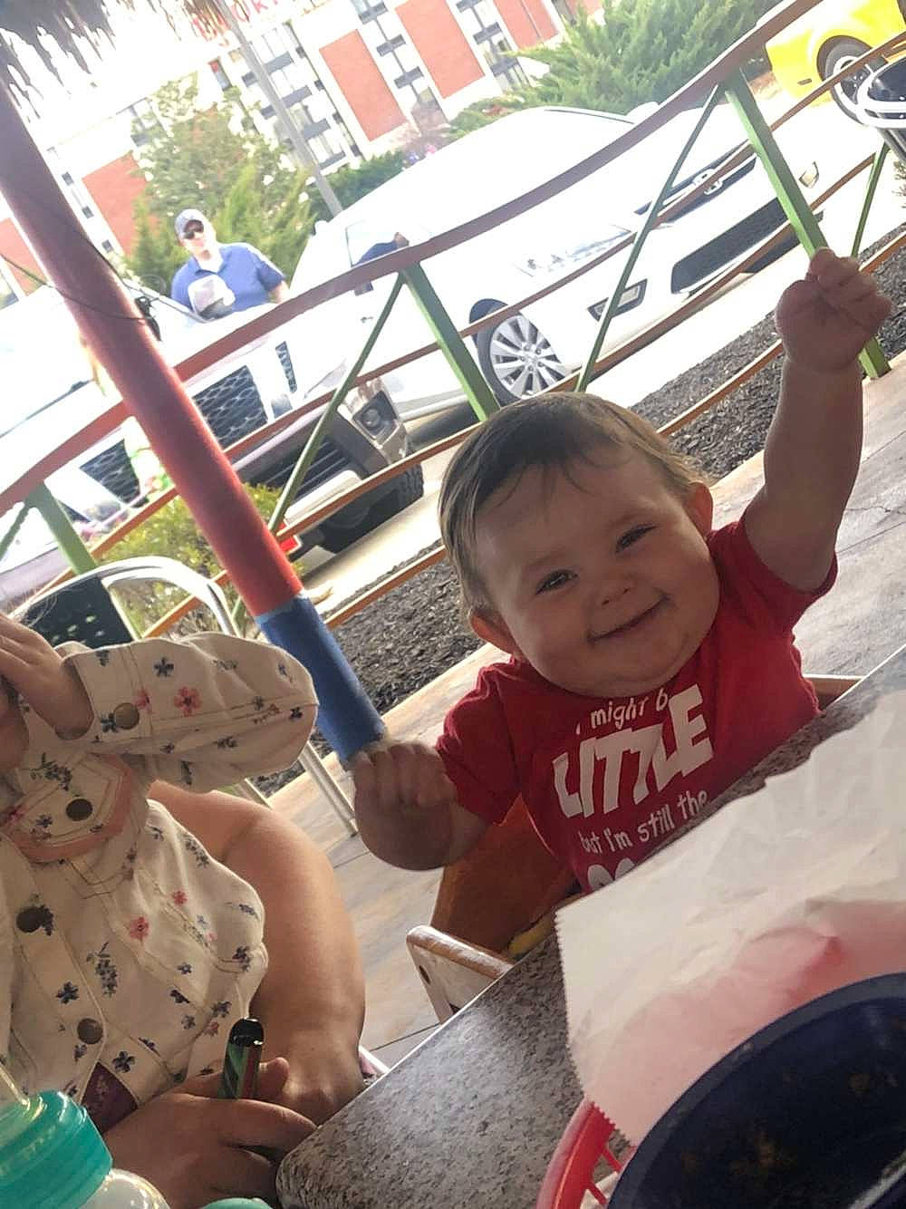 Jace is registered to the contest to win money with this photo: auto_part, automotive_exterior, baby, baby_toddler_clothing, child, event, fun, happy, joy, lap, leisure, motor_vehicle, person, recreation, sitting, smile, t_shirt, toddler, tourism, travel