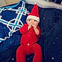 Penelope is registered to the contest to win money with this photo: baby, infant, red_onesie, red_hat, holiday, christmas, sparkles, blanket, pillow, cozy, cute, lying_down, indoors, child, face, hands, soft_texture, patterned_pillow, festive, adorable