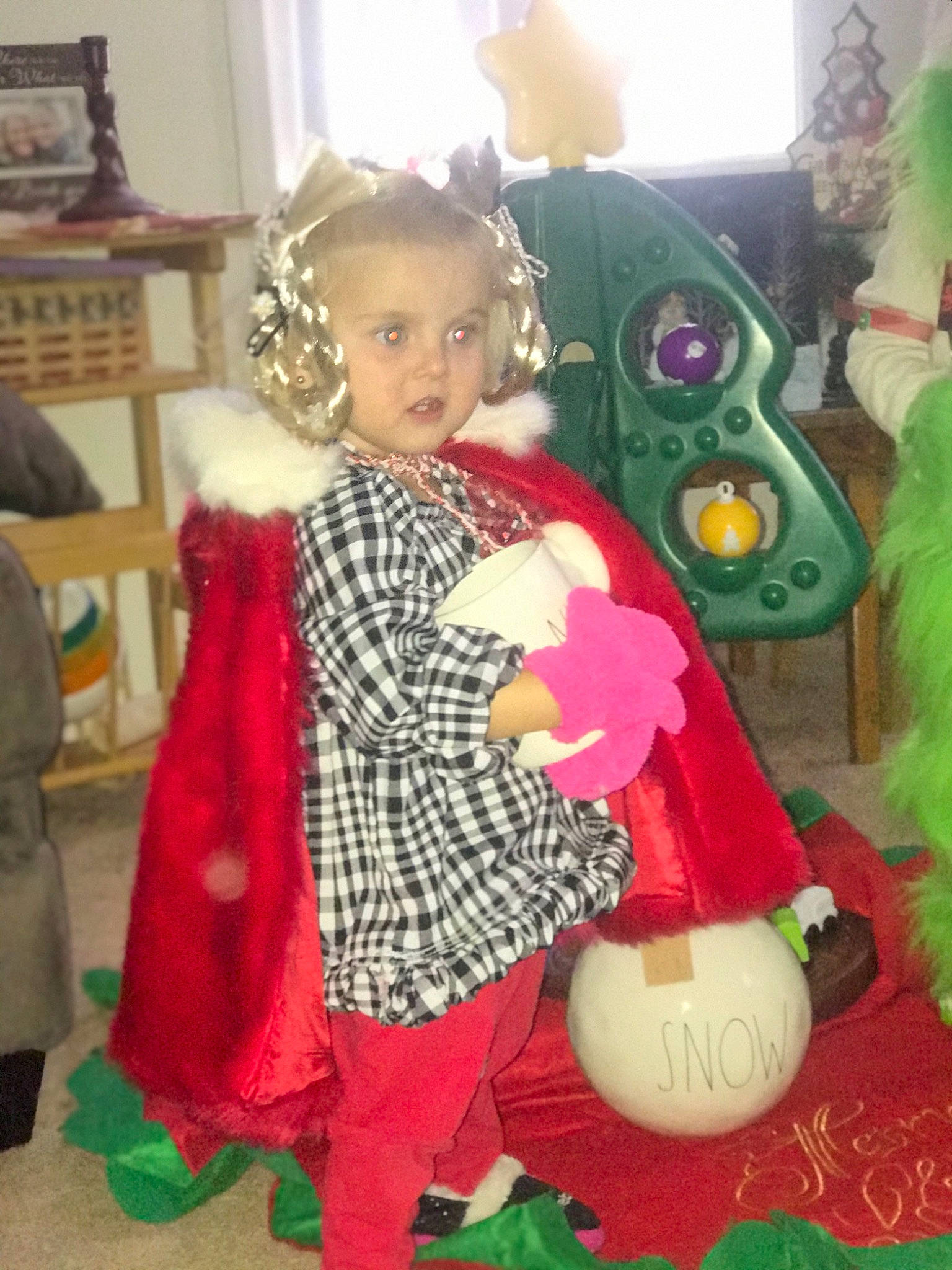 Kaydence is registered to the contest to win money with this photo: baby_toddler_clothing, bookcase, child, christmas, christmas_eve, costume, event, fun, fur, happy, holiday, mammal, party, party_supply, person, pink, room, shelf, standing, toddler