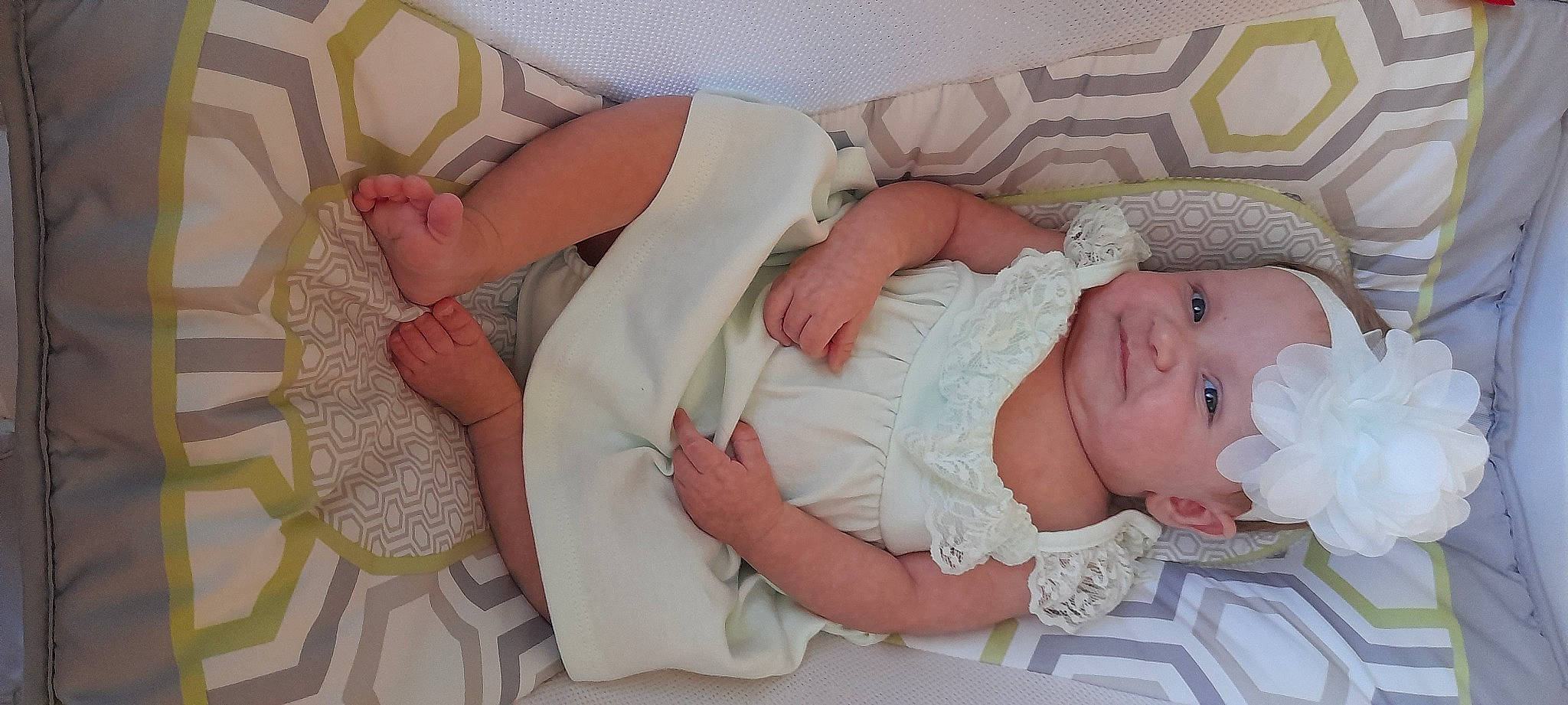 Layne is registered to the contest to win money with this photo: baby, baby_products, baby_toddler_clothing, cheek, child, comfort, finger, hand, headwear, human_body, leg, linens, nail, pattern, peach, person, pink, room, skin, textile