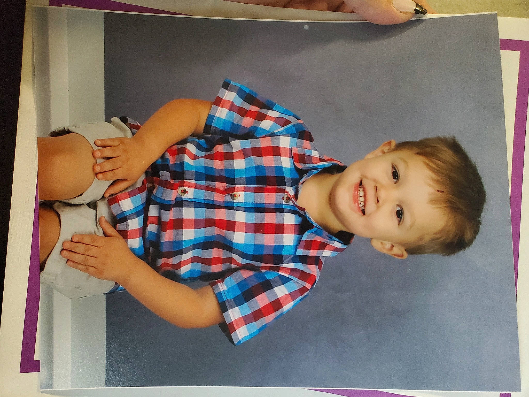 Garrett is registered to the contest to win money with this photo: chair, child, comfort, fun, gesture, happy, human_leg, joy, linens, pattern, person, plaid, product, rectangle, room, sitting, sleeve, smile, tartan, textile