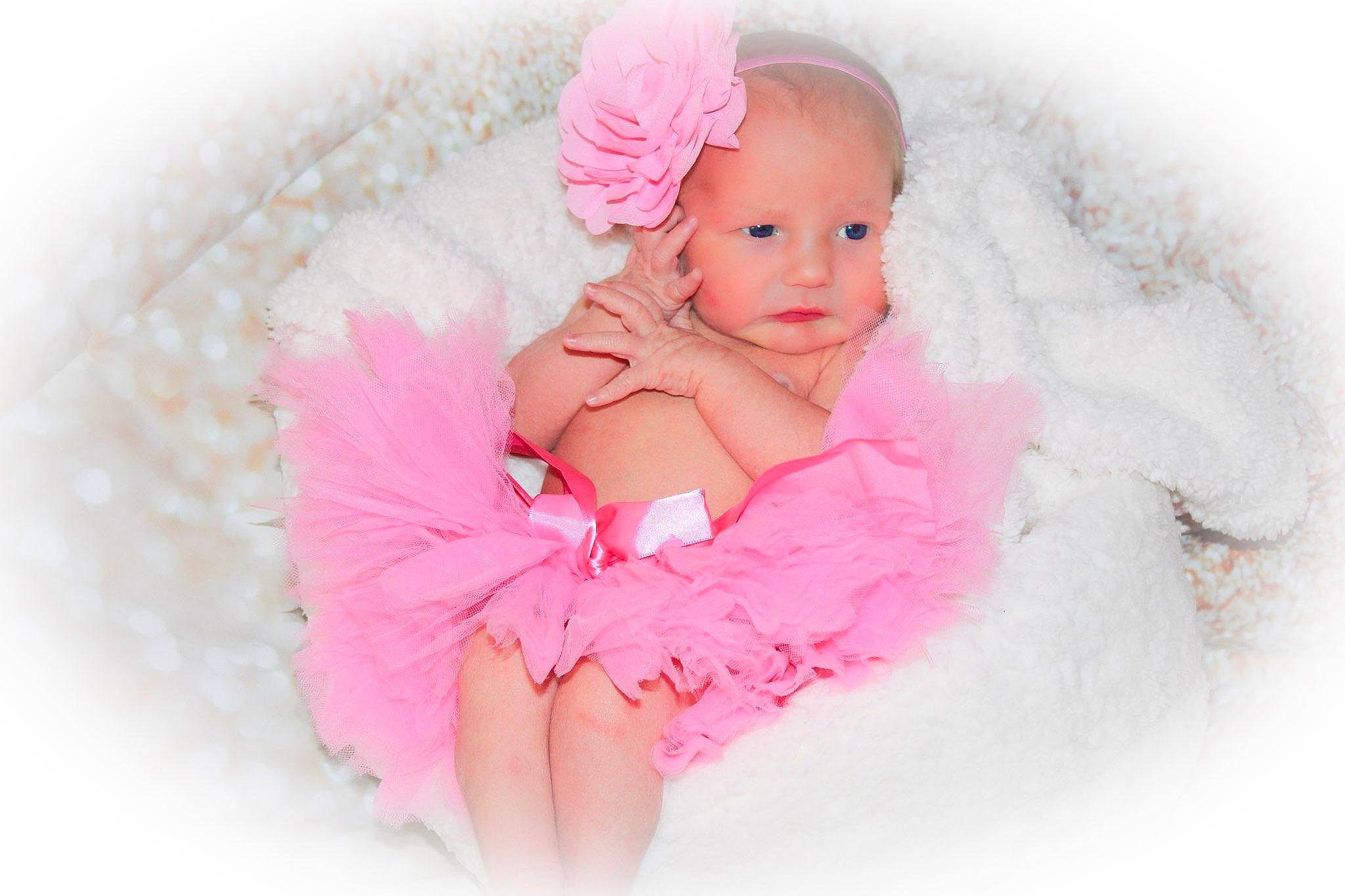 Lily is registered to the contest to win money with this photo: baby, baby_toddler_clothing, child, costume_hat, day_dress, dress, embellishment, fashion_accessory, flash_photography, hair_accessory, happy, headpiece, magenta, pattern, peach, person, petal, pink, ruffle, sleeve