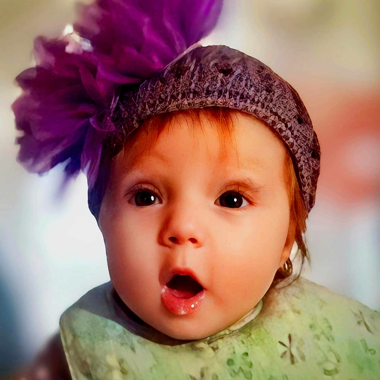 Abbi joined the competition — help win amazing prizes! baby, child, portrait, close_up, face, wide_eyed, surprised, smiling, hat, flower_hat, purple_flower, infant, green_clothing, patterned_clothing, sitting, indoor, soft_lighting, colorful, adorable, photography