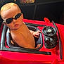 baby, child, sunglasses, toy_car, red, indoor, steering_wheel, milk, cute, seat, person, toddler, play, vehicle, wheel, furniture, small, shirtless, hand, face