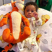 Malachi is registered to the contest to win money with this photo: baby, child, plush_toy, tigger, winnie_the_pooh, pajamas, blanket, bed, indoor, cute, infant, stuffed_animal, soft_toy, childrens_clothing, face, person, home, comfort, sleepwear, furniture