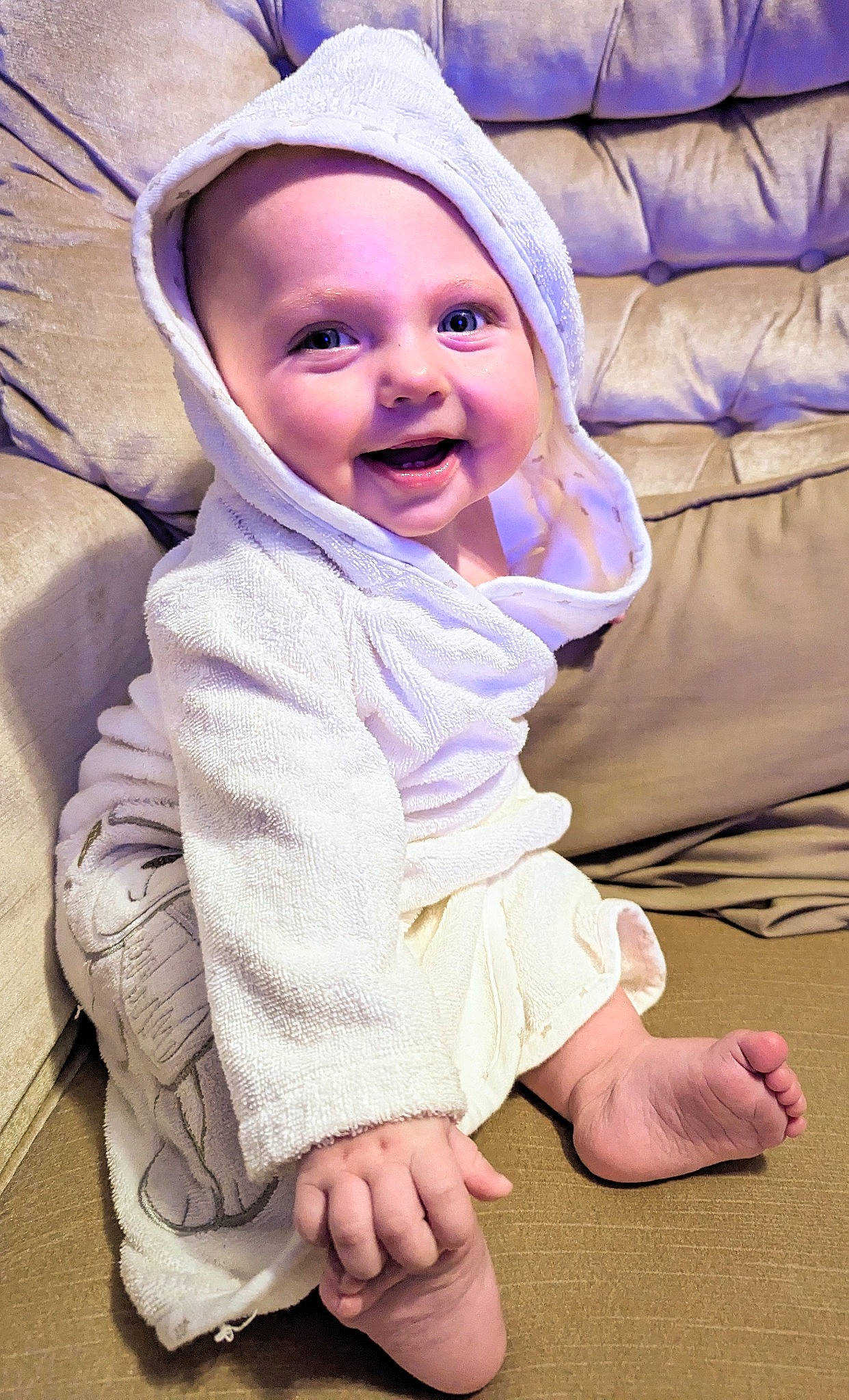 Stevie is registered to the contest to win money with this photo: baby, baby_toddler_clothing, cap, child, comfort, eye, face, finger, flooring, foot, fun, happy, hat, headwear, joy, linens, person, purple, sitting, skin