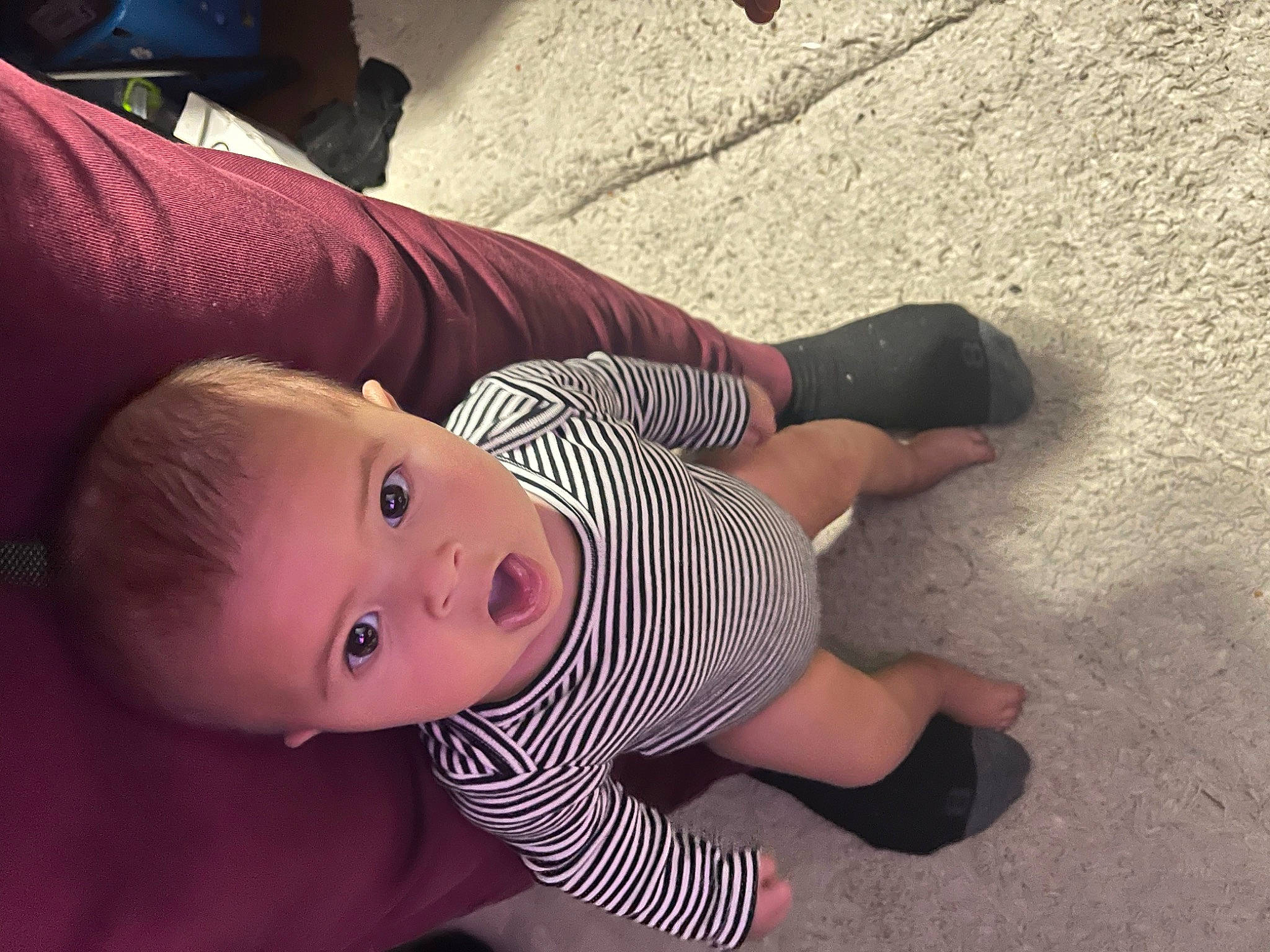 Everleigh is registered to the contest to win money with this photo: baby, baby_toddler_clothing, cheek, child, finger, flooring, foot, fun, gesture, grass, hat, human_leg, leg, nose, person, sitting, skin, sleeve, surprise, toddler