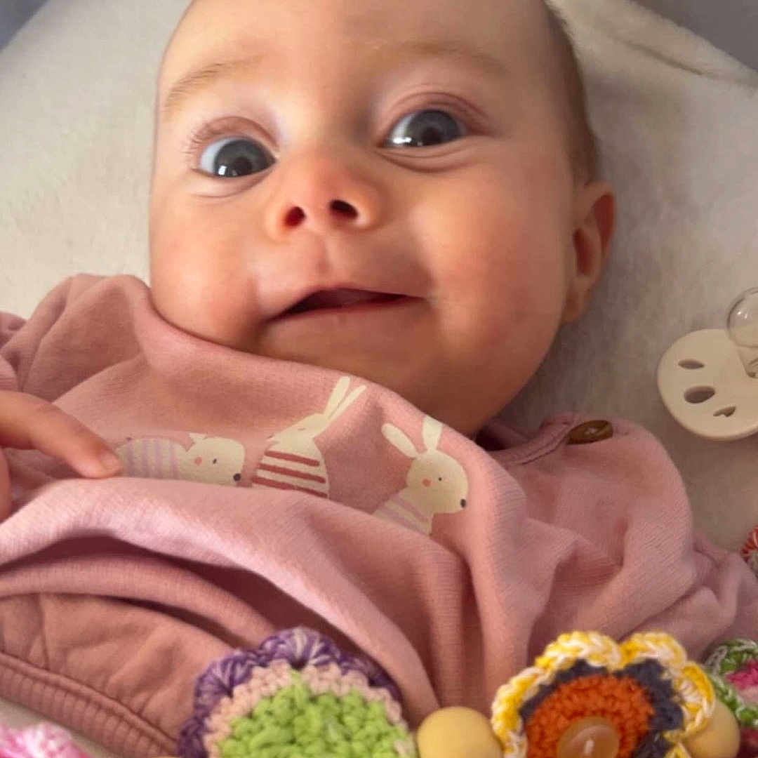 Ariana participe au concours pour gagner de l'argent avec cette photo : adorable, baby, blanket, bunny_print, cheeks, close_up, clothing, crochet_toy, cute, infant, lying_down, nursery, onesie, pacifier, pacifier_clip, portrait, smiling, soft_texture, wide_eyes, wooden_beads
