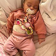 Ariana a rejoint le concours — aidez-le/la à gagner de superbes lots ! baby, infant, newborn, child, sleeping, pacifier, pacifier_clip, pink_clothing, crochet_toy, beads, blanket, pillow, bed, onesie, socks, hand, closed_eyes, cute, cozy, portrait