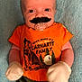 baby, bodypart, clothing, couch, face, finger, furniture, glove, hand, happy, head, laughing, mouth, mustache, person, photography, portrait, t_shirt, teeth, toy