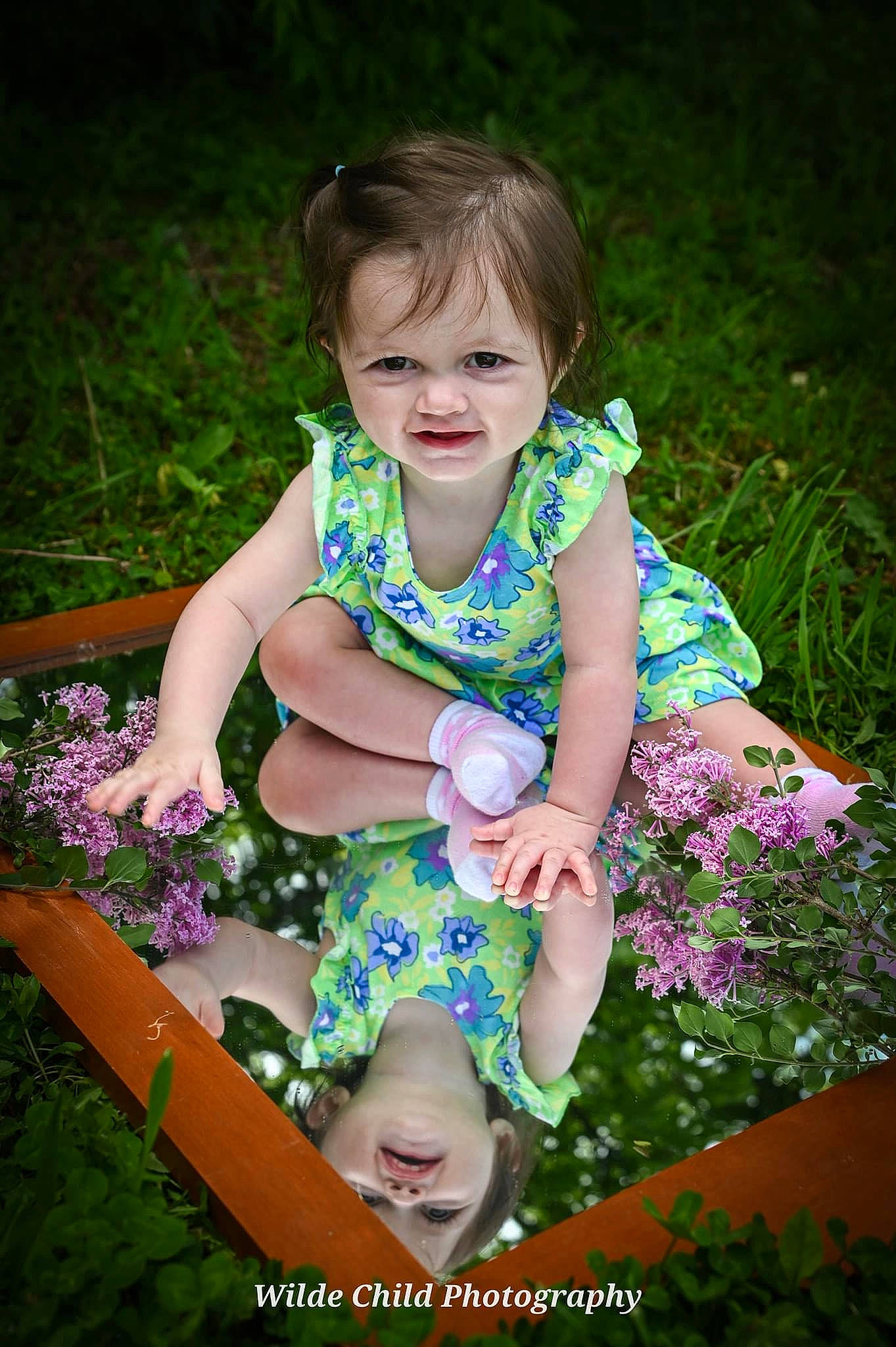 Bliss is registered to the contest to win money with this photo: baby_toddler_clothing, botany, dress, eye, face, flash_photography, grass, happy, iris, leaf, leisure, nature, people_in_nature, person, photograph, pink, plant, purple, skin, terrestrial_plant