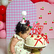 Paulina joined the competition — help win amazing prizes! balloons, birthday, birthday_cake, cake, cake_stand, celebration, cherries, child, curly_hair, dessert, dress, festive, indoors, party_hat, pink, portrait, red, sitting, toddler, white