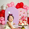 Paulina is registered to the contest to win money with this photo: baby, balloons, birthday, cake, cake_table, celebration, cherries, child, curious, decorations, dress, indoors, infant, party, pink, portrait, red, sitting, studio, white