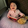 Paulina joined the competition — help win amazing prizes! baby, blanket, book, child, curly_hair, cushion, face, happy, indoor, infant, nursery, onesie, pink_outfit, portrait, reading, sitting, smiling, storybook, stuffed_animal, teddy_bear