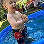 toddler, child, pool, water, swim_trunks, summer, outdoor, happy, splashing, wet_hair, backyard, picnic, people, table, chair, grass, sunlight, daytime, fun, play