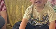 Bodie is registered to the contest to win money with this photo: toddler, child, smiling, barefoot, sitting, bench, yellow_blanket, graphic_tee, happy, outdoor, greenery, sky, portrait, casual, cute, people, candid, daylight, fun, young_child