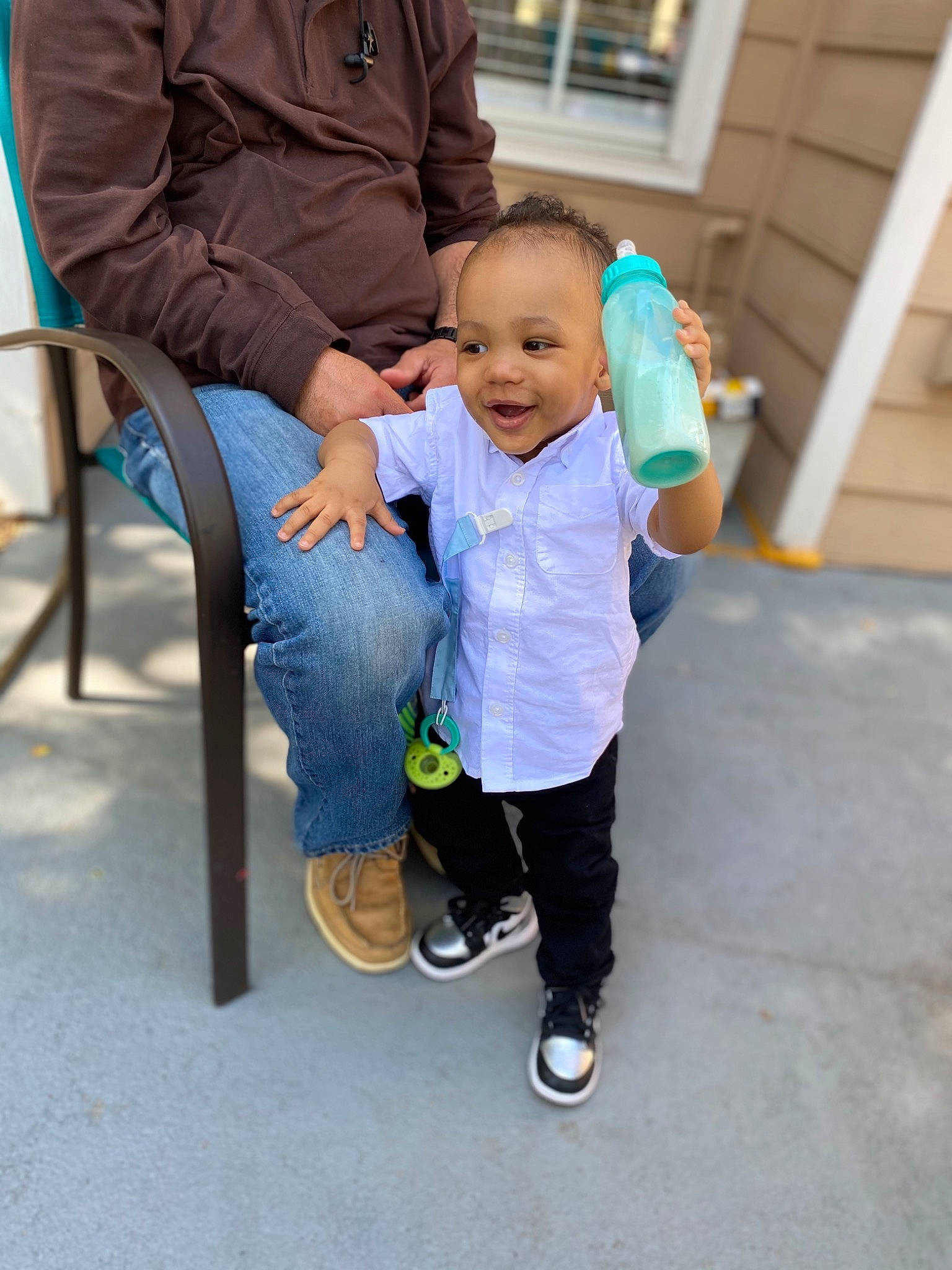 Tre is registered to the contest to win money with this photo: baby, baby_toddler_clothing, child, electric_blue, event, footwear, fun, gesture, grass, happy, jacket, lap, leisure, person, recreation, sandal, shoe, sitting, smile, sneakers