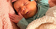 Valerie joined the competition — help win amazing prizes! newborn, baby, sleeping, portrait, face, hands, blanket, fleece, pink, cream, green_clothing, indoors, cozy, peaceful, resting, infant, closed_eyes, soft_texture, close_up, photography