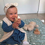 Layana participe au concours pour gagner de l'argent avec cette photo : baby, blue_dress, child, cute, floor, girl, happy, headband, indoor, mat, patterned, playful, portrait, sitting, smiling, sock, teddy_bear, tights, toy, wooden_block