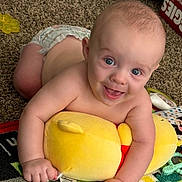 Xavier joined the competition — help win amazing prizes! baby, child, smiling, blue_eyes, plush_toy, yellow, carpet, diaper, indoor, play_mat, happy, cute, infant, crawling, skin, person, young, toy, floor, childhood