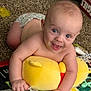 baby, child, smiling, blue_eyes, plush_toy, yellow, carpet, diaper, indoor, play_mat, happy, cute, infant, crawling, skin, person, young, toy, floor, childhood