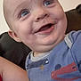 Xavier is registered to the contest to win money with this photo: baby, child, smiling, blue_eyes, close_up, shirt, patterned_clothing, couch, indoor, happy, face, person, infant, cute, young_child, portrait, seated, skin, human, expression