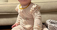 Vivian is registered to the contest to win money with this photo: baby, blanket, child, cozy, curious, cute, face, footed_pajamas, hand, headband, home, indoor, infant, outfit, pink, plush, portrait, rug, sitting, sofa